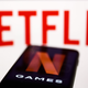 The Netflix logo in front of a cellphone showing "N GAMES".